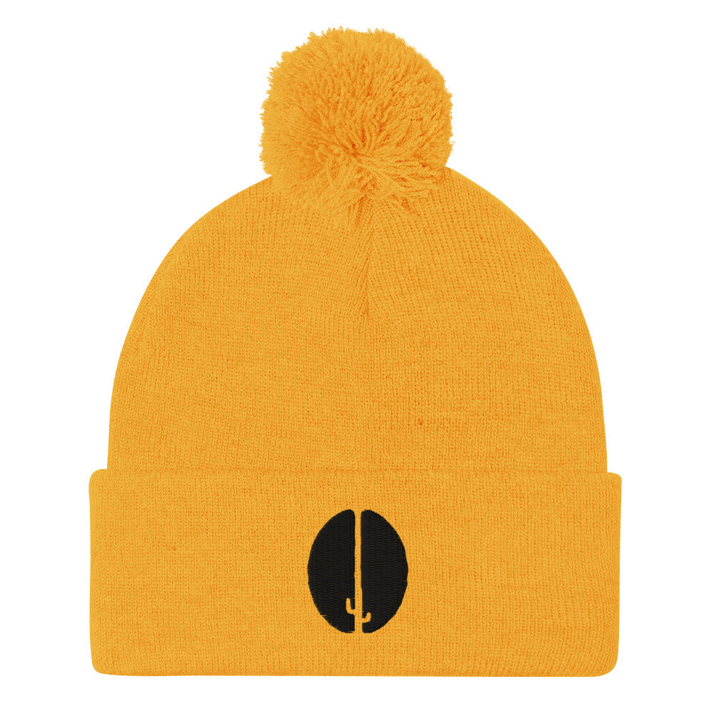 A yellow beanie with a pom-pom on top and a black saguaro bean embroidery on the front.