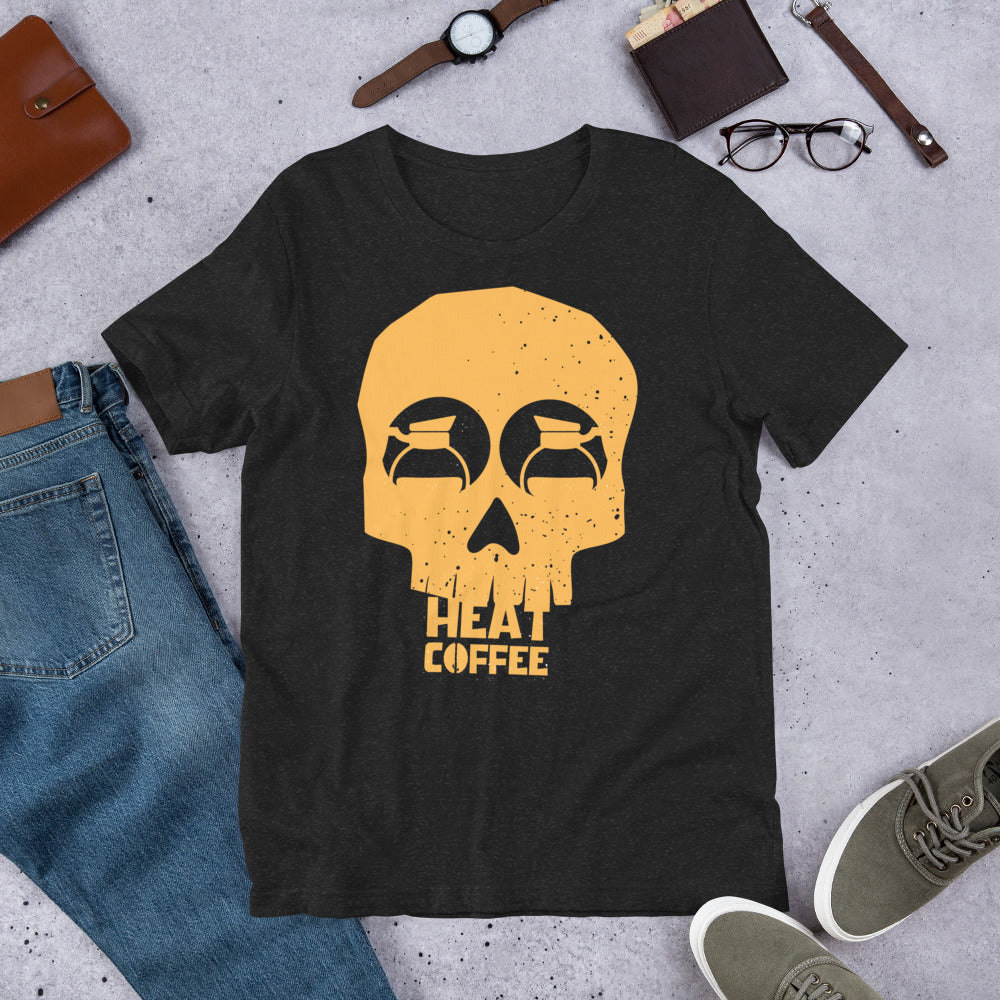 A black unisex t-shirt with a graphic of a skull and the text 'HEAT Coffee' on it, displayed on a surface with a pair of jeans, a pair of sneakers, a leather bag, a watch, and a pair of eyewear.